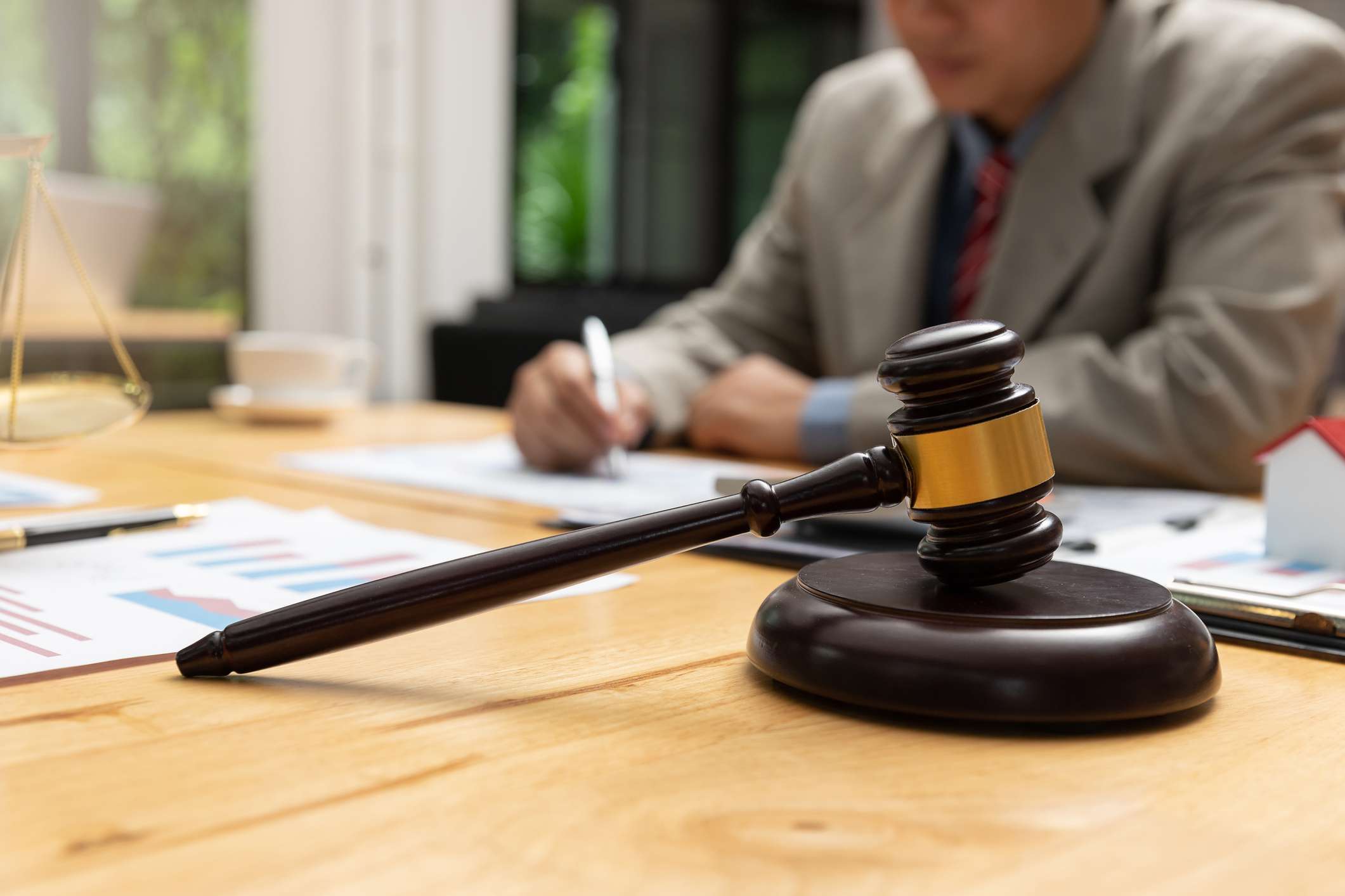 Lawyer and businessman working and discussing business contract papers in office.