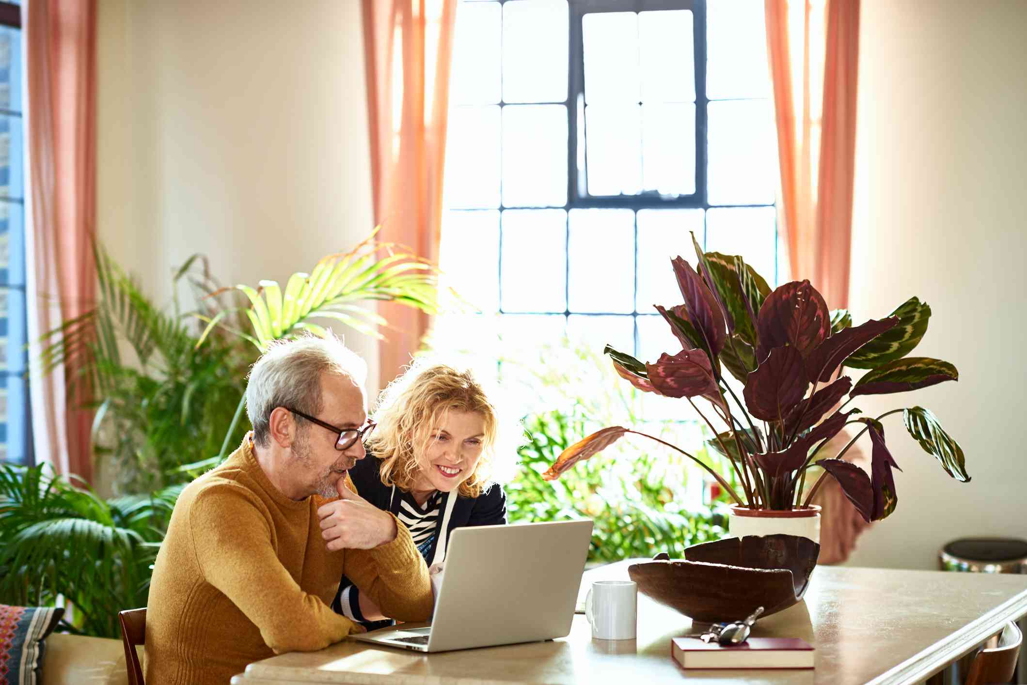 a couple looking at their laptop in their living room