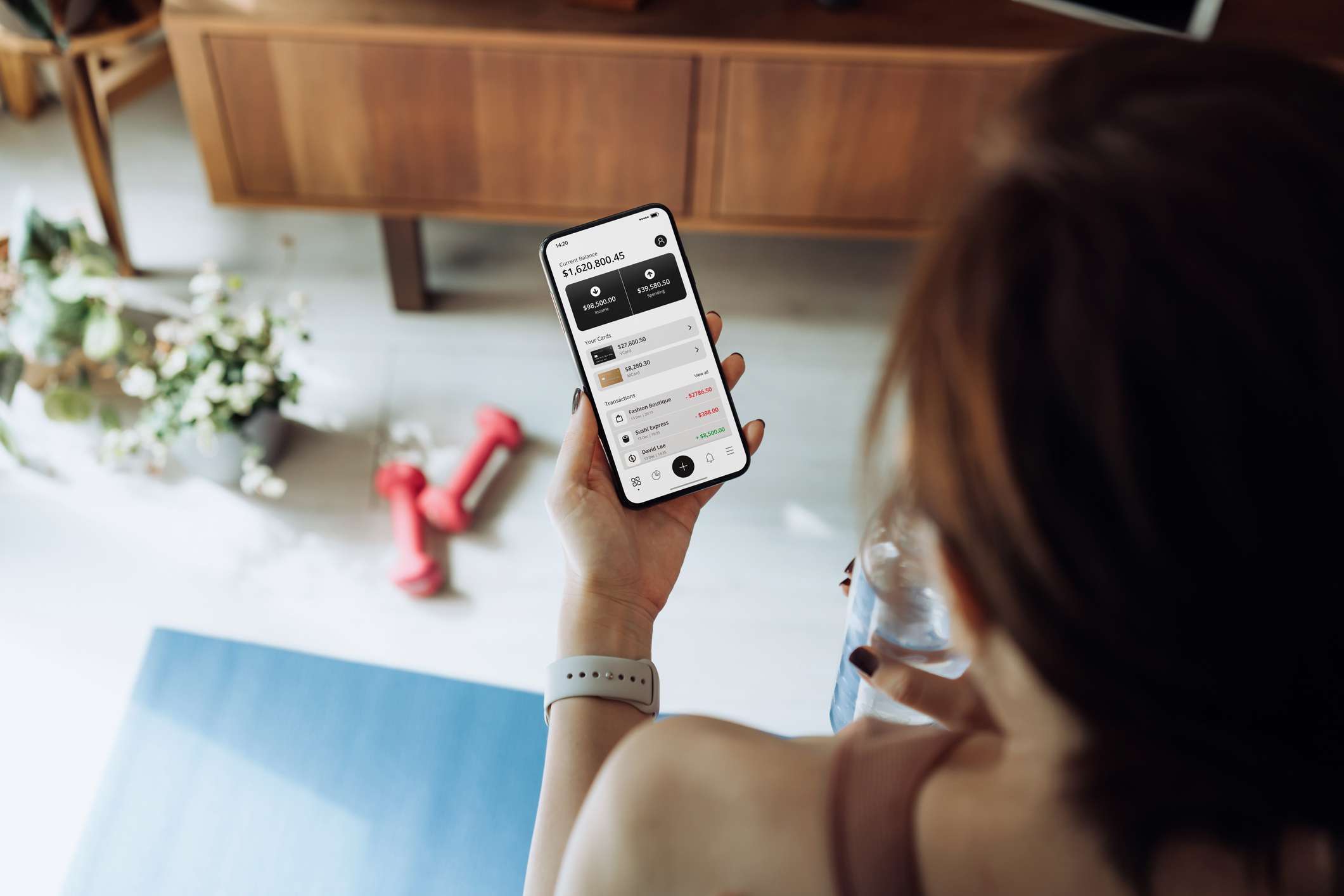 Over the shoulder view of a person looking at bank account information on their smartphone